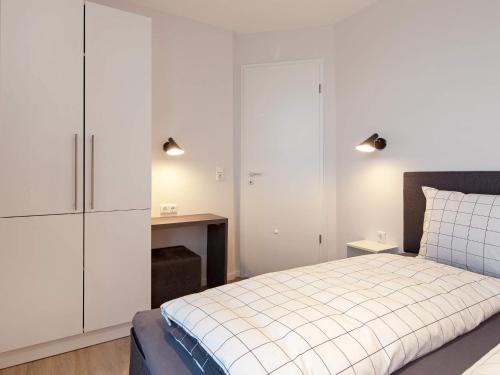 een slaapkamer met een bed en een witte kast bij Apartment Wendtorf IV in Wendtorf