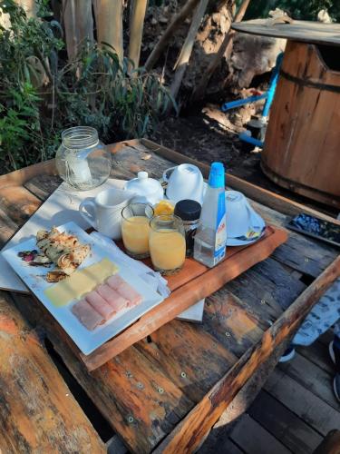 a table with a plate of food and glasses of orange juice at Bosques del Paico in El Monte