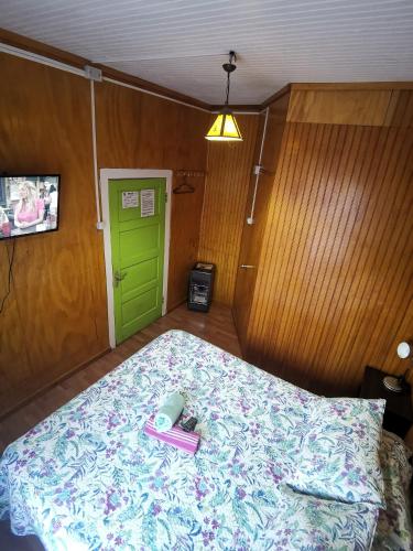 a bedroom with a bed with a pair of pink shoes on it at Hostal y Cabañas Maribel Zuñiga in Valdivia
