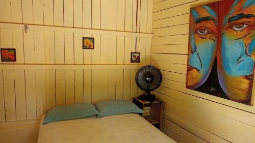 a room with a bed and a painting on the wall at Pousada Grão in Belém