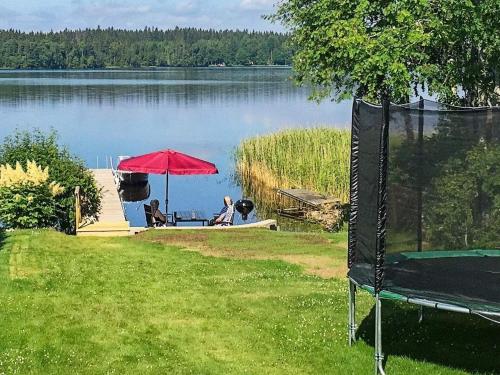 a view of a lake with a red umbrella at 6 person holiday home in N SSJ in Nässjö