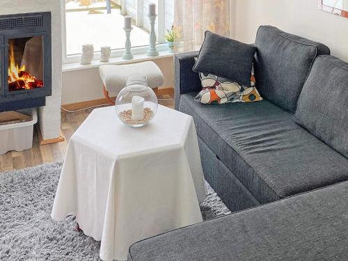 a living room with a couch and a table with a fireplace at 6 person holiday home in N SSJ in Nässjö