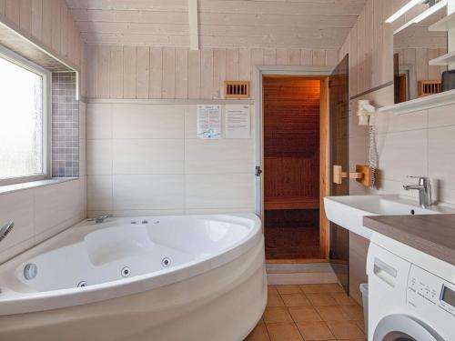 y baño con bañera blanca y lavamanos. en Three-Bedroom Holiday home in Grömitz 2, en Grömitz