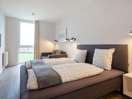a bedroom with a large bed with a couch at Apartment Wendtorf VII in Wendtorf