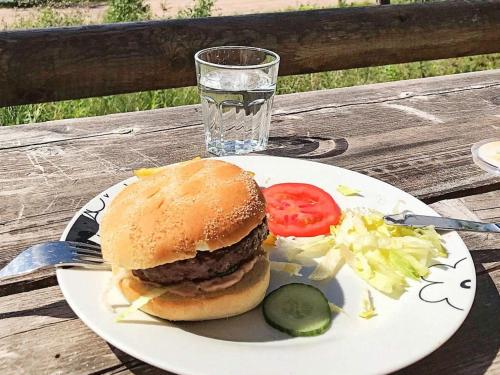 a plate with a hamburger and salad and a glass of water at 6 person holiday home in SÄLEN-By Traum in Tandådalen