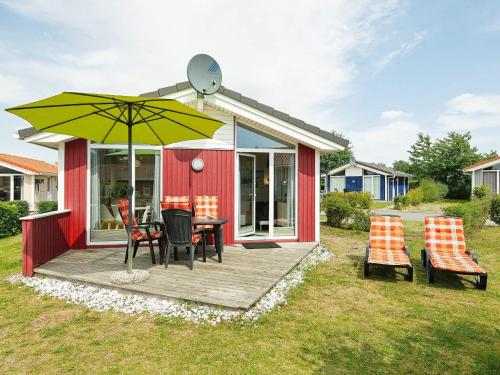 a deck with a table and chairs and an umbrella at 4 person holiday home in GROEMITZ in Grömitz