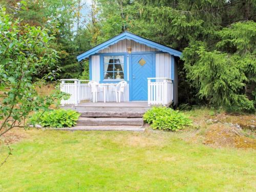 un cobertizo azul y blanco en un patio en 6 person holiday home in TROLLH TTAN en Trollhättan