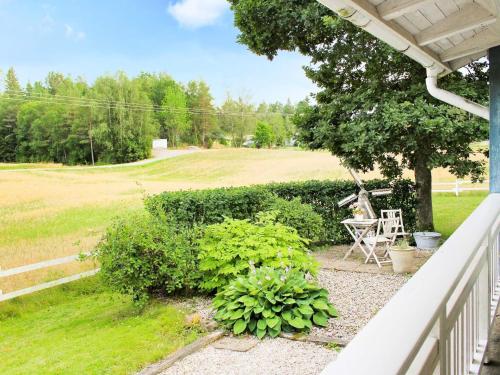 a porch with a table and some plants and a field at 6 person holiday home in TROLLH TTAN in Trollhättan