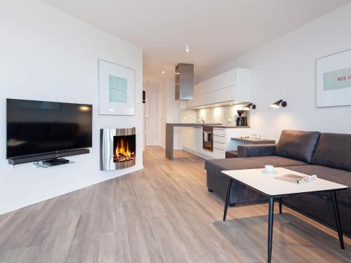 a living room with a couch and a fireplace at Cozy Modern Apartment with Sea Views in Wendtorf