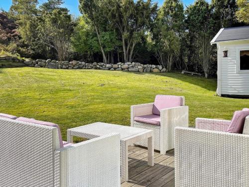 un grupo de sillas y una mesa en un patio en 5 person holiday home in N sund, en Nösund
