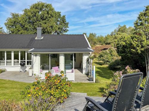 una casa con un porche con sillas rosas en el patio en 5 person holiday home in N sund, en Nösund
