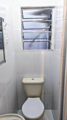 a bathroom with a toilet and a window at 10 Studios in Sao Paulo