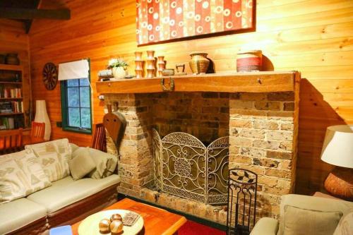 a living room with a couch and a fireplace at Holly Lodge in Medlow Bath