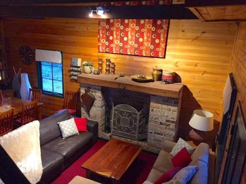ein Wohnzimmer mit einem Sofa und einem Kamin in der Unterkunft Holly Lodge in Medlow Bath