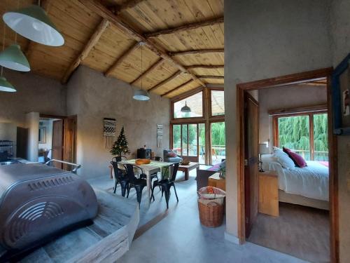 una camera con una camera da letto, un letto e un tavolo di Piuquenes Lodge - Cabañas Valle de Elqui a Horcon