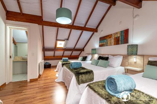 2 camas en una habitación con techos de madera en Sua Casa em Canela, en Canela