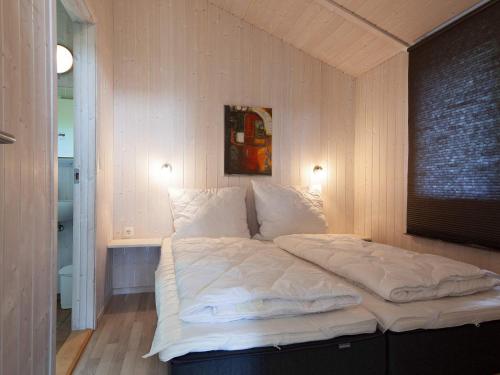 1 cama con sábanas blancas y almohadas en una habitación en Two-Bedroom Holiday home in Grömitz 7, en Grömitz