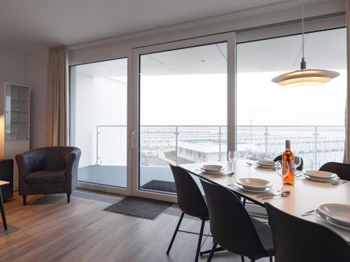 a dining room with a table and chairs and a large window at 6 Personen Ferienhaus in Wendtorf in Wendtorf
