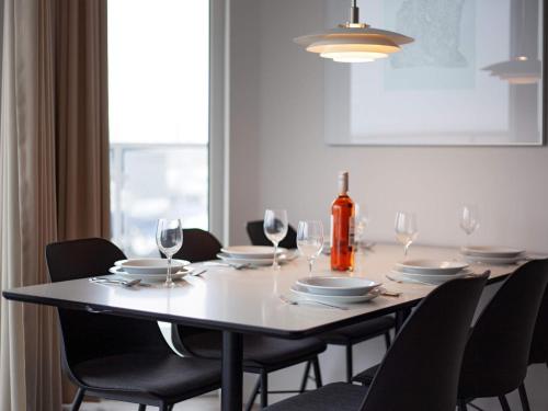 a dining room table with chairs and a bottle of wine at 6 Personen Ferienhaus in Wendtorf in Wendtorf