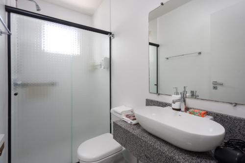 a bathroom with a sink and a glass shower at Apartamento DES ARTS-Vista Mar in Balneário Camboriú