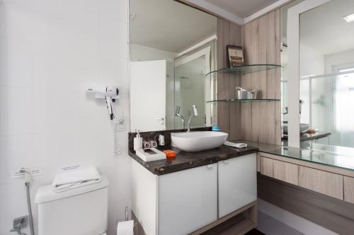 y baño con lavabo y espejo. en Apartamento Vista Mar, en Balneário Camboriú