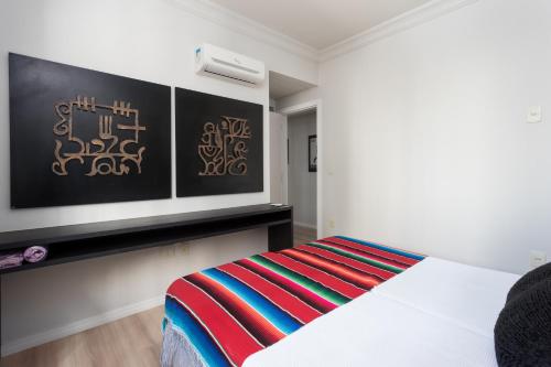 a bedroom with a bed and a wall with a tv at Apartamento DES ARTS-Vista Mar in Balneário Camboriú