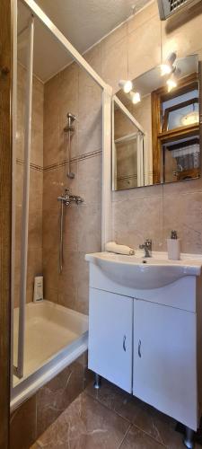 a bathroom with a sink and a shower and a tub at House Old town stone house in Stari Grad