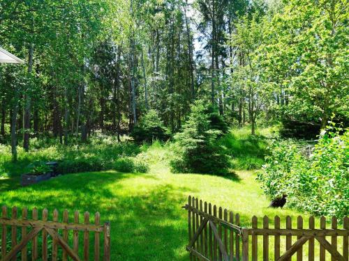 um jardim com uma cerca de madeira na relva em 6 person holiday home in EKER em Ekerö