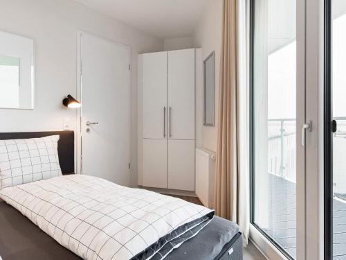 a bedroom with a bed and a large window at Apartment Wendtorf XI in Wendtorf