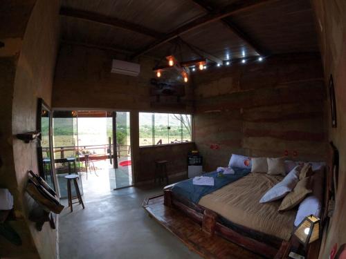 a bedroom with a bed in a wooden house at Pousada Toca da Raposa in Cavalcante