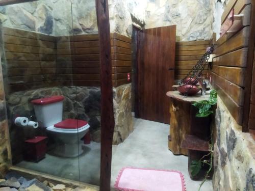 a bathroom with a toilet in a stone wall at Pousada Toca da Raposa in Cavalcante