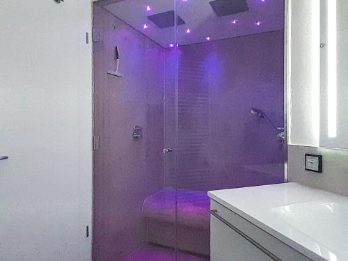 um chuveiro roxo com luzes roxas numa casa de banho em Apartment Wendtorf XIII em Wendtorf