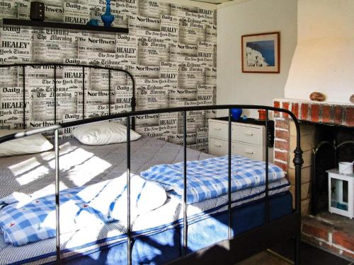 Dormitorio con litera y pared de periódico en One-Bedroom Holiday home in Lerdala 1, en Lerdala