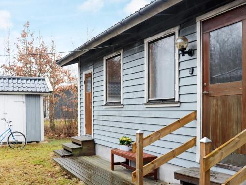 uma pequena casa com um alpendre e uma porta de madeira em 4 person holiday home in Heberg em Heberg