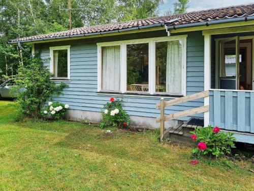 uma casa azul com uma janela e flores no quintal em 4 person holiday home in Heberg em Heberg