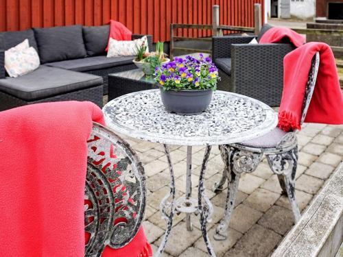 una mesa con una maceta de flores en un patio en 5 person holiday home in LINDOME SVERIGE 