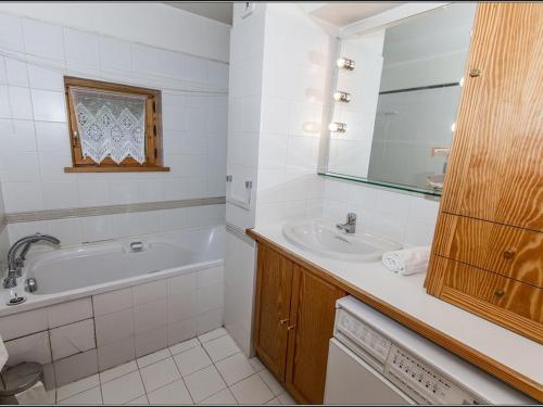 une salle de bain blanche avec une baignoire et un lavabo dans l'établissement Duplex 4 pièces au pied des pistes avec balcon et parking couvert à Val d'Isère - FR-1-518-92, à Val dʼIsère
