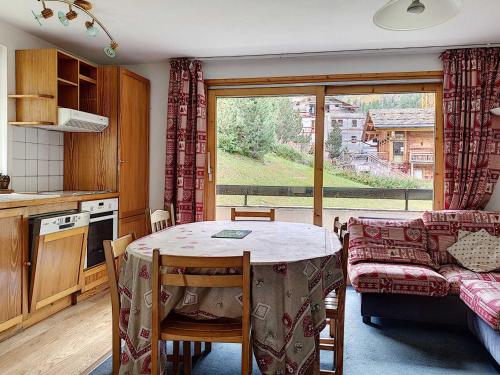 une cuisine et une salle à manger avec une table et une fenêtre dans l'établissement Duplex 4 pièces au pied des pistes avec balcon et parking couvert à Val d'Isère - FR-1-518-92, à Val dʼIsère
