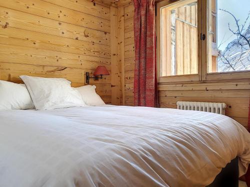 a bed in a wooden room with a window at Appartement Val-d'Isère, 2 pièces, 2 personnes - FR-1-518-130 in Val-d'Isère