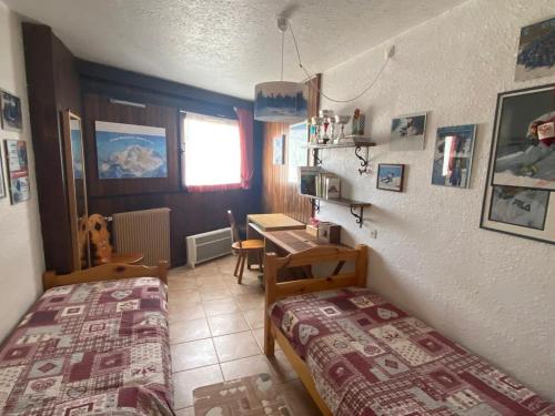 um quarto com 2 camas, uma secretária e uma mesa em Appartement Montgenèvre, 3 pièces, 6 personnes - FR-1-445-183 em Montgenèvre