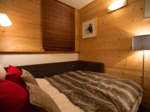 une chambre avec un lit dans une pièce aux murs en bois dans l'établissement Appartement rénové 22 m² - Val Thorens - 3 pers - Skis aux pieds - Confort & WiFi - FR-1-637-42, à Val Thorens