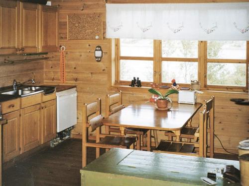 eine Küche mit einem Holztisch mit Stühlen und einem Waschbecken in der Unterkunft Seven-Bedroom Holiday home in Flatanger 2 in Straum