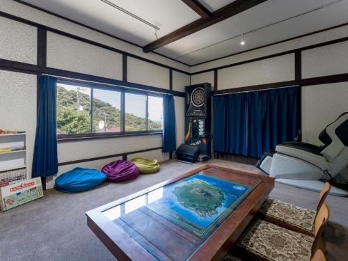 癒楽 伊豆大島 في Oshima: غرفة معيشة مع طاولة في الوسط