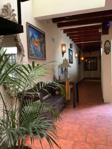 a hallway of a building with a table and plants at La casita de Angie in Antigua Guatemala