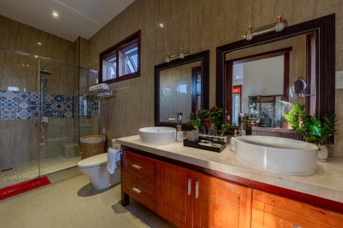 La salle de bains est pourvue de 2 lavabos, d'une douche et de toilettes. dans l'établissement Sông River Homestay Hội An, à Hội An