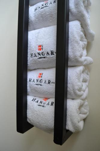 a group of towels in a towel rack in a bathroom at Hangar Inn Guadalajara Aeropuerto in Guadalajara