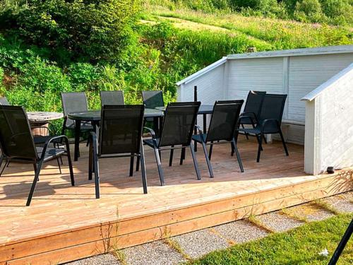 una mesa y sillas en una terraza de madera en 9 person holiday home in KORTGARDEN, 