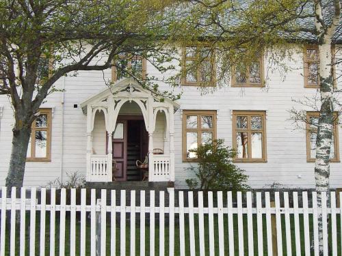 a white house with a white fence in front of it at 15 person holiday home in Flatanger in Stokke