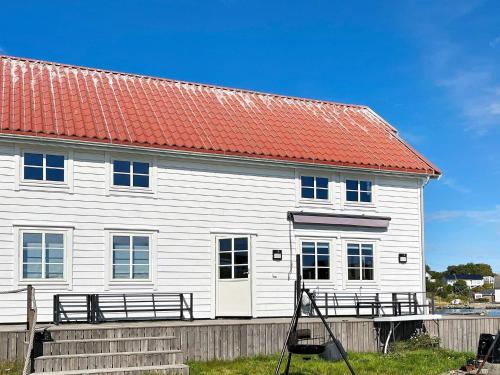 a white house with an orange roof at 12 person holiday home in bremnes-By Traum in Bremnes