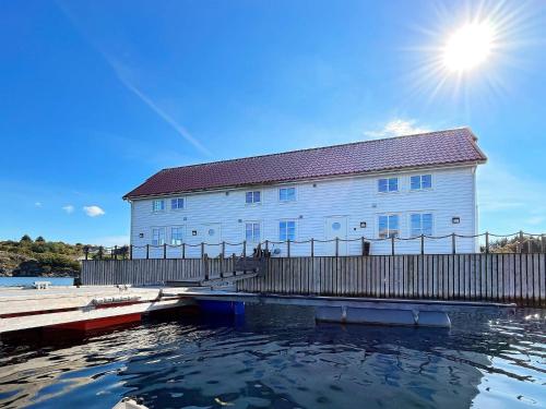 a building with a dock and water in front of it at 12 person holiday home in bremnes-By Traum in Bremnes